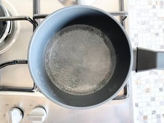 Una pentola d'acqua è posta sopra un fornello.