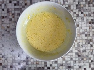 Una ciotola di uova è appoggiata su un bancone piastrellato.