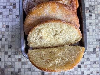 Una pagnotta di pane è appoggiata su una teglia di metallo su un tavolo.