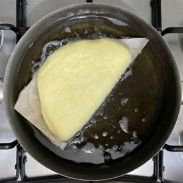 Una tortilla viene cotta in una pentola d'acqua sul fornello.