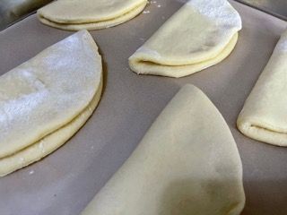 Diversi pezzi di pasta sono appoggiati su un tavolo