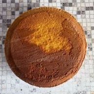 Una torta è appoggiata su un tavolo piastrellato.