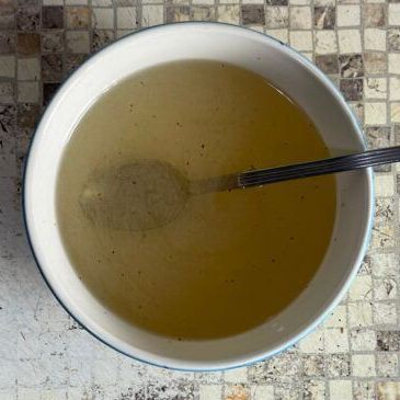 Una ciotola di zuppa con un cucchiaio dentro su un tavolo.