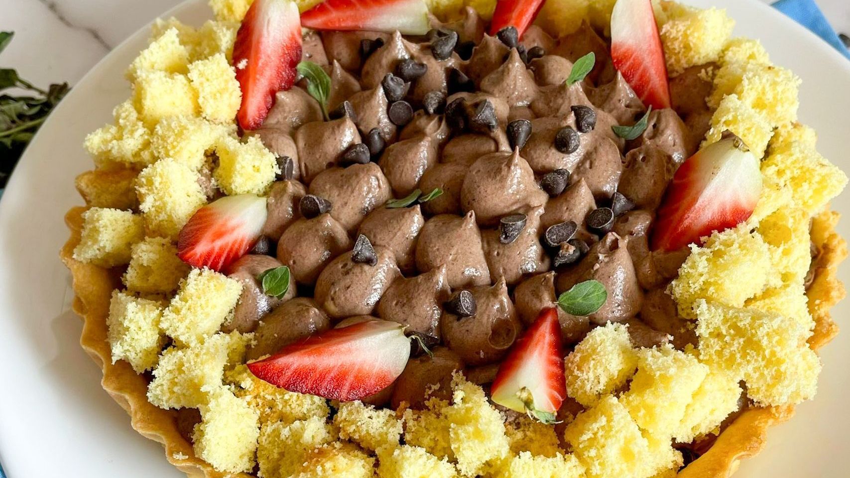Un primo piano di un dessert con fragole e gocce di cioccolato su un piatto.