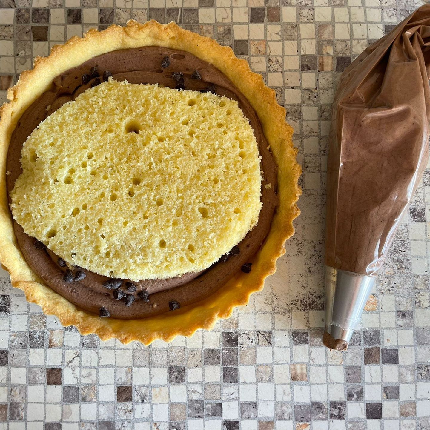 Una torta con un pezzo di torta dentro accanto a una sac à poche
