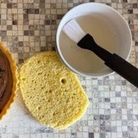 C'è una ciotola di liquido accanto a un pezzo di pane.