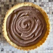 Una torta ricoperta di glassa al cioccolato è appoggiata su un tavolo.