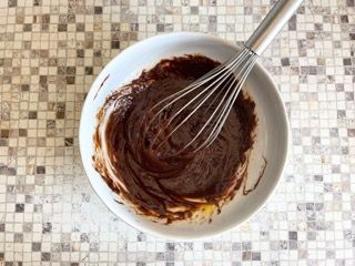 Una ciotola di salsa al cioccolato con una frusta dentro.