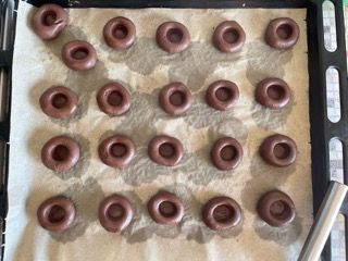 Un vassoio di ciambelle al cioccolato su un pezzo di carta oleata