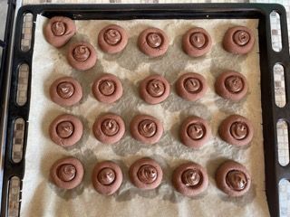 Un vassoio di biscotti al cioccolato appoggiato su un foglio di carta oleata.