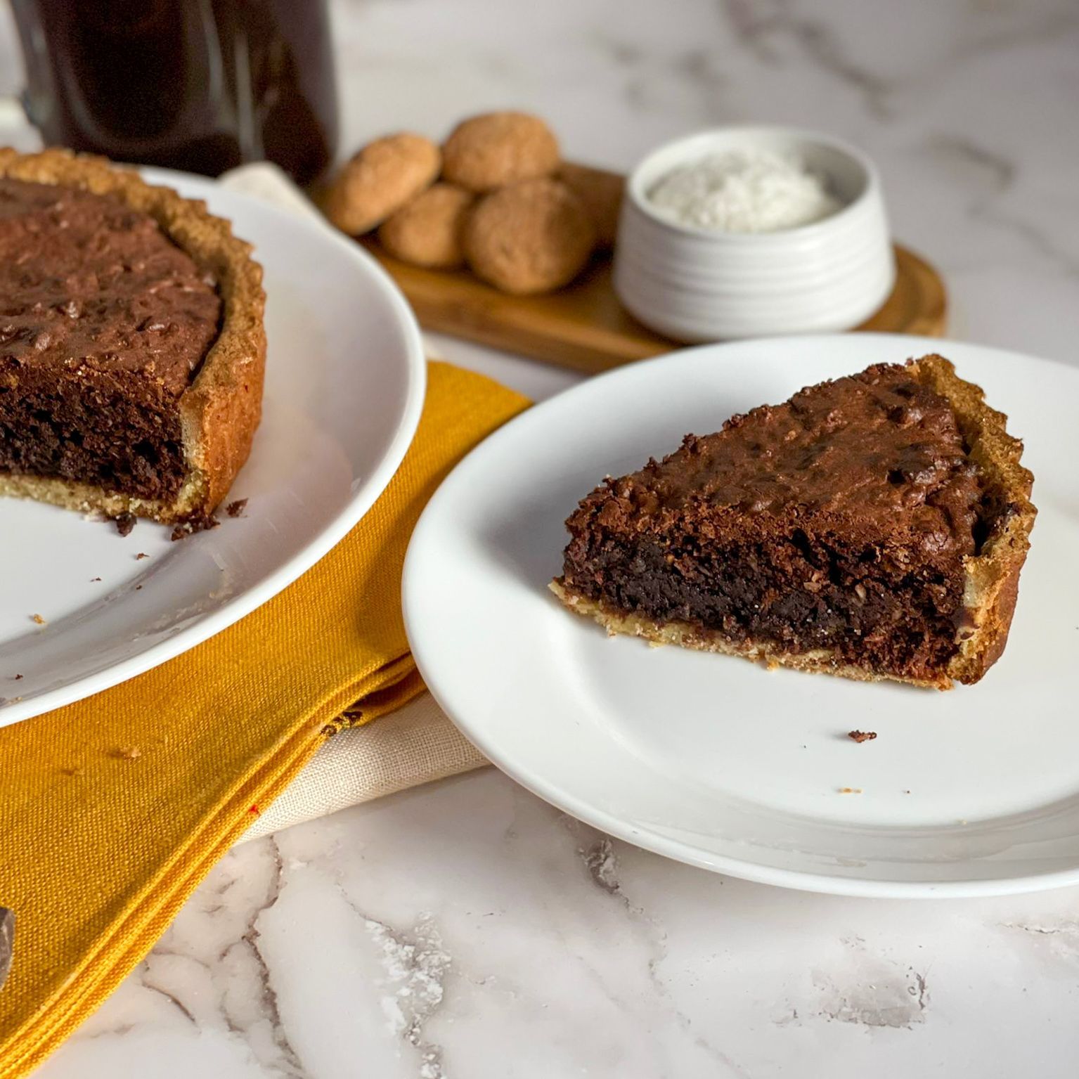 Una fetta di torta al cioccolato è su un piatto bianco