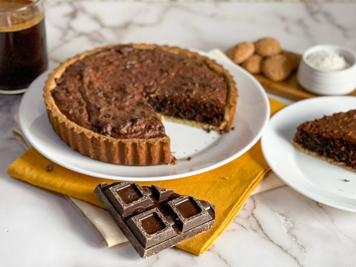 Una torta al cioccolato con una fetta staccata è su un piatto.