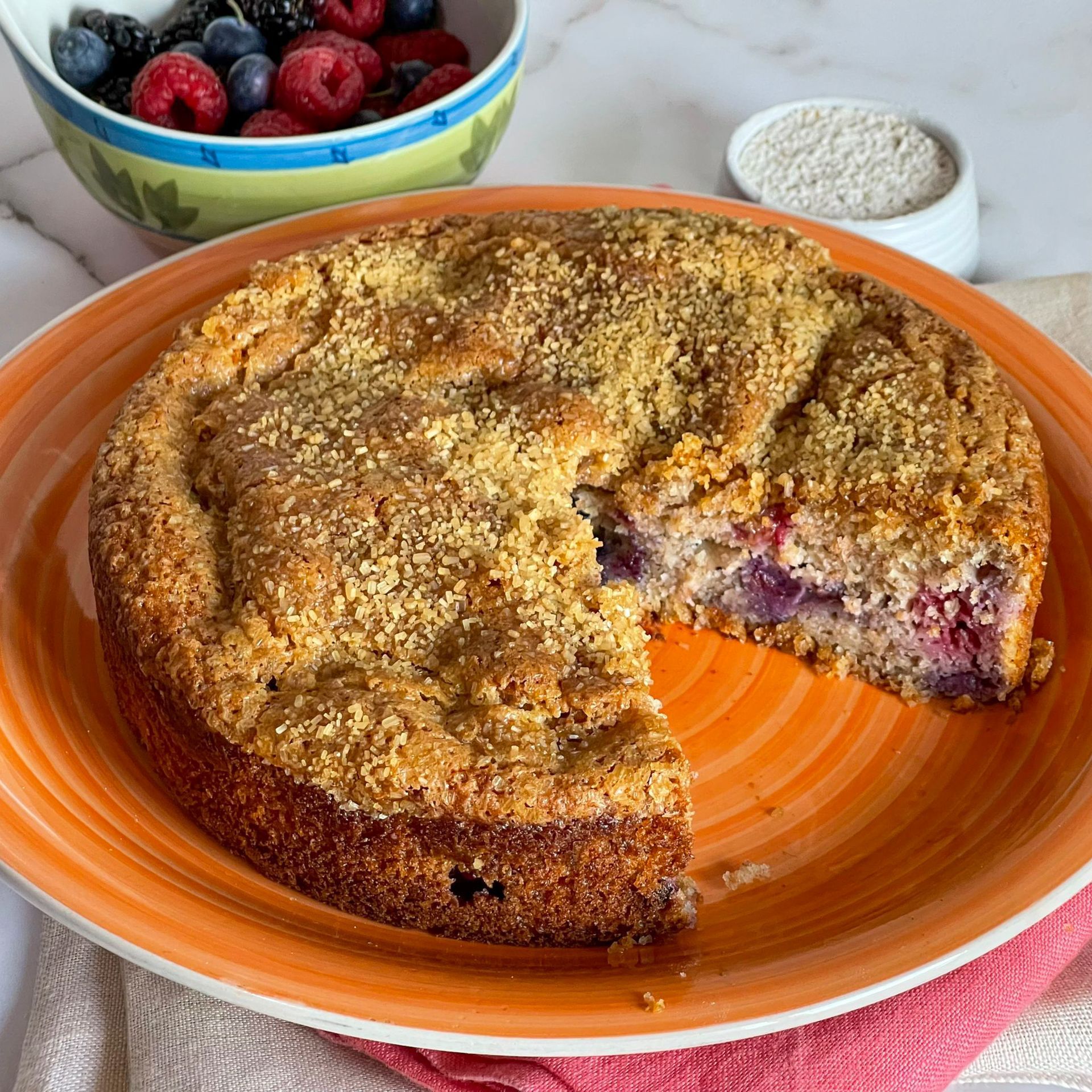 Una torta con una fetta staccata si trova su un piatto arancione.