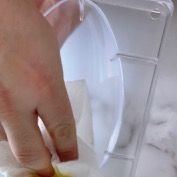 Un primo piano della mano di una persona che tiene un contenitore di plastica.