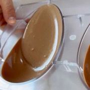 Una persona sta versando un liquido marrone in una ciotola di vetro.