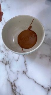 Una persona sta versando del cioccolato in una ciotola su un tavolo.