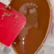 Una persona sta versando del cioccolato in una ciotola a forma di cuore.