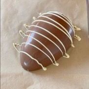 Una fragola ricoperta di cioccolato con glassa bianca è appoggiata su un tavolo.