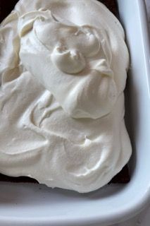 Un primo piano di una fetta di torta con panna montata sopra
