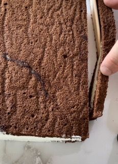 Primo piano di una persona che taglia una fetta di torta al cioccolato.