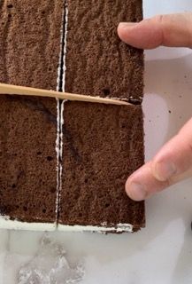 Una persona sta tagliando una fetta di torta al cioccolato con uno stuzzicadenti.