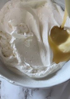 Una persona versa del liquido in una ciotola di panna montata.