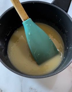 Una spatola verde è in una pentola di liquido