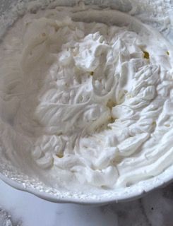 Un primo piano di panna montata in una ciotola su un tavolo.