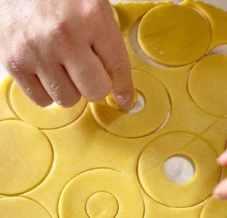 Una persona sta tagliando l'impasto in cerchi con le dita