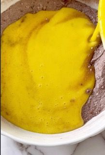 Una persona sta versando del liquido giallo in una ciotola di cibo.