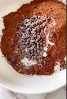 Un piatto bianco condito con cacao in polvere e gocce di cioccolato