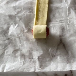 Un pezzo di formaggio è appoggiato su un foglio di carta oleata.