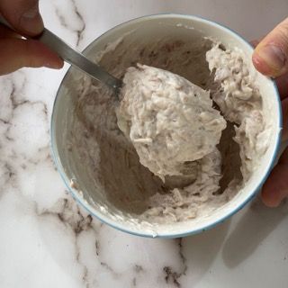 Una persona sta mescolando qualcosa in una ciotola con un cucchiaio