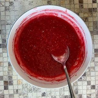 Una ciotola di liquido rosso con un cucchiaio dentro