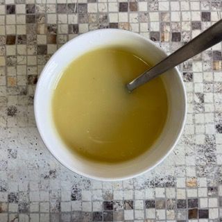 Una ciotola di zuppa con un cucchiaio dentro su un tavolo.