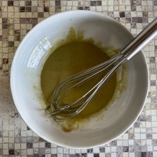 Una ciotola di liquido con una frusta dentro