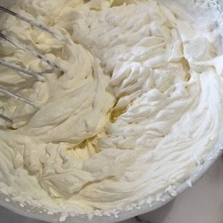 Una ciotola di panna montata con una frusta dentro.