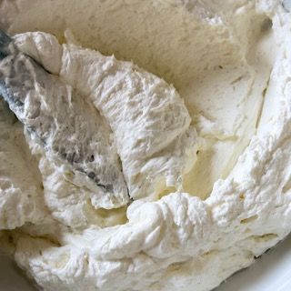 Una ciotola di panna montata con una spatola dentro.