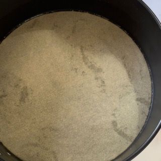 Una padella nera riempita con una sostanza bianca.