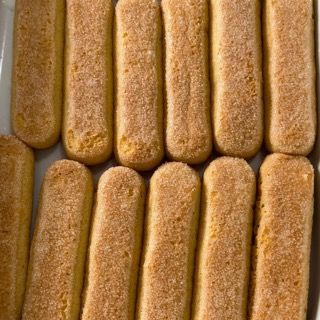 Primo piano di un vassoio di biscotti al tiramisù su un tavolo.