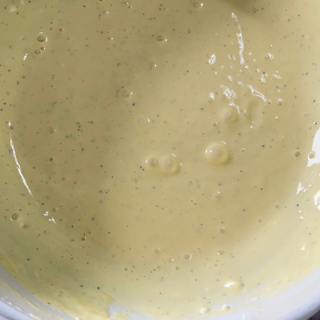 Primo piano di una ciotola bianca piena di un liquido giallo.