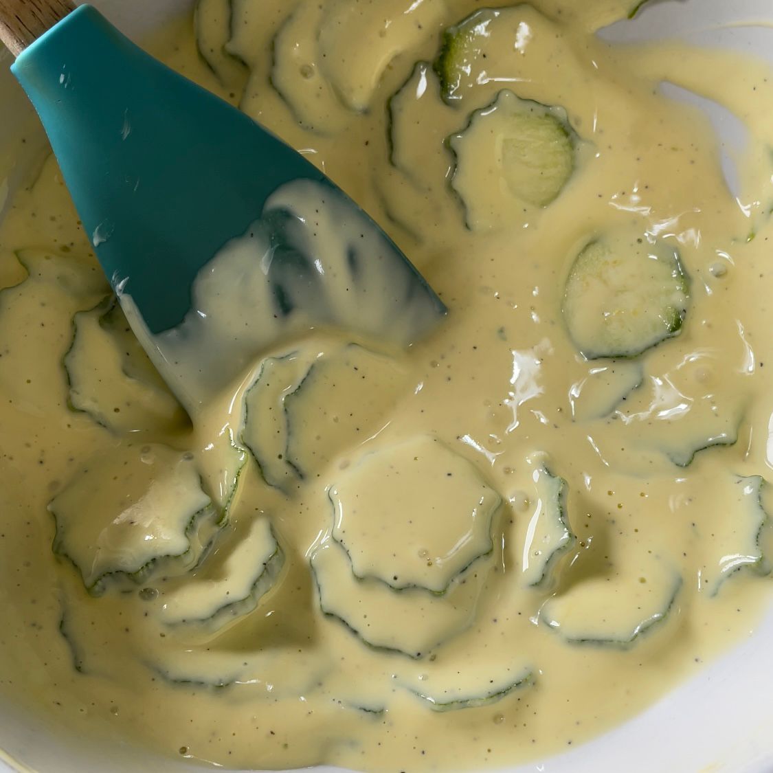 Una ciotola di salsa con cetrioli e una spatola dentro