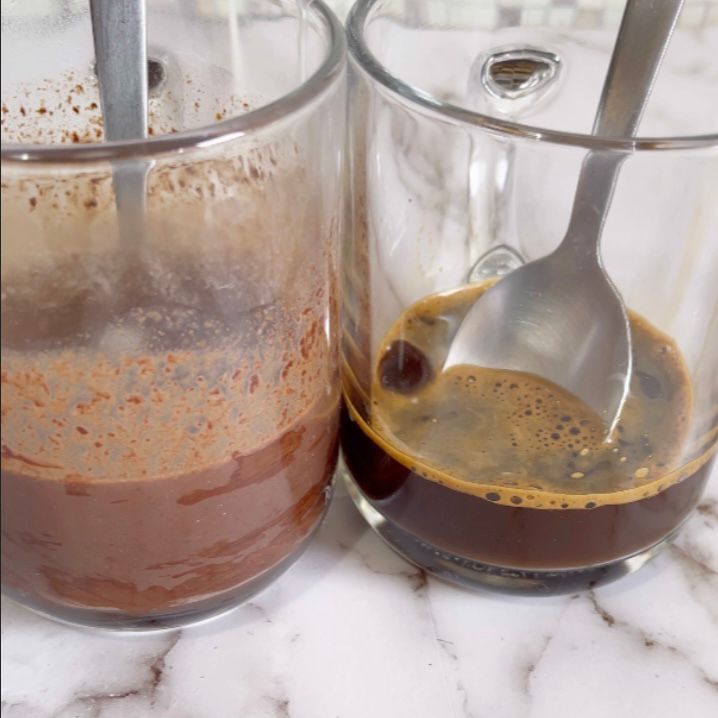 Due tazze di caffè con cucchiaini dentro su un tavolo