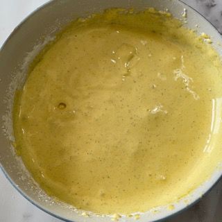 Primo piano di una ciotola di salsa gialla su un tavolo.