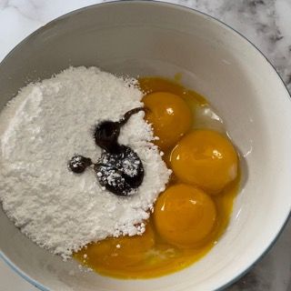 Una ciotola di uova e zucchero a velo su un tavolo