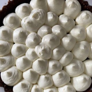 Un primo piano di una torta con panna montata sopra