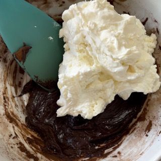 Una ciotola di cioccolato e panna montata con una spatola
