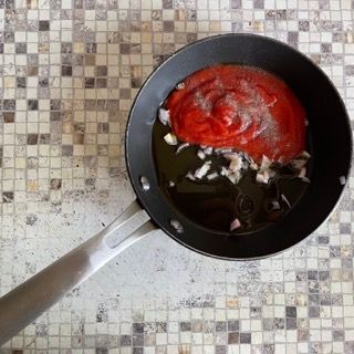 Una padella piena di salsa di pomodoro e cipolle