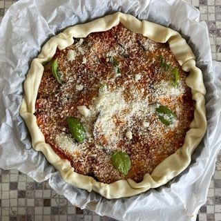 Una pizza è appoggiata su un pezzo di carta oleata