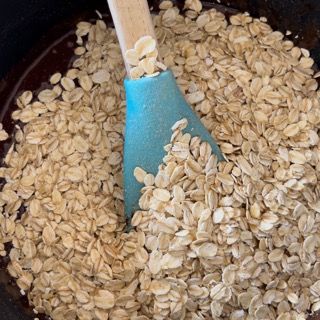 Un cucchiaio blu è in un mucchio di avena